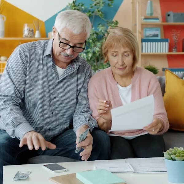 An older couple at home working through a form together.